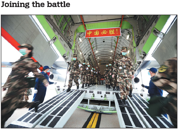 Medical personnel from the People's Liberation Army get off a military transport aircraft at Wuhan Tianhe International Airport in Hubei province on Thursday, marking the first civilian-related mission carried out by the PLA's Y-20 transport aircraft. The 1,400 military medical workers, boarding 11 aircraft, will be joined by another 1,200 colleagues in the latest effort to fight the novel coronavirus pneumonia outbreak in Wuhan.Chen Xiaodong/for China Daily