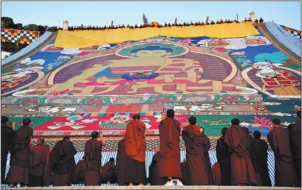 The traditional "sunning of the Buddha "ceremony, with a giant thangka painting unfurled on a slope near Drepung Monastery in Lhasa, Tibet autonomous region, is held on Wednesday to mark the beginning of the annual Shoton Yogurt Festival.Zhan Yan/xinhua