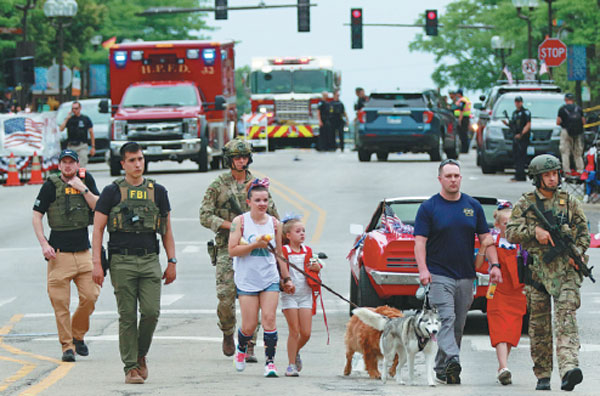Law enforcement officers escort a family away from the scene of a mass shooting where six people were killed and more than 25 injured during a Fourth of July parade on Monday in Highland Park, Illinois, in the United States.Mark Borenstein/getty Images/Afp
