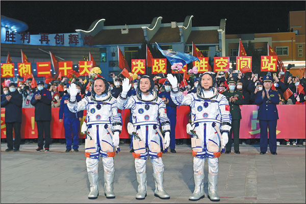 Crew members of the Shenzhou XV space mission - Major General Fei Junlong (right), Senior Colonel Deng Qingming (center) and Senior Colonel Zhang Lu - wave during a ceremony on Tuesday night prior to their departure from Jiuquan Satellite Launch Center in Northwest China.Wang Jiangbo/for China Daily