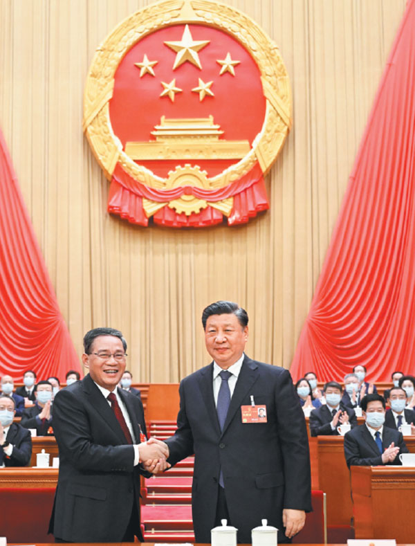 President Xi Jinping shakes hands with Li Qiang at the fourth plenary meeting of the first session of the 14th National People's Congress in the Great Hall of the People in Beijing on Saturday. Li was endorsed as China's premier at the meeting upon nomination by Xi.Li Xueren/Xinhua