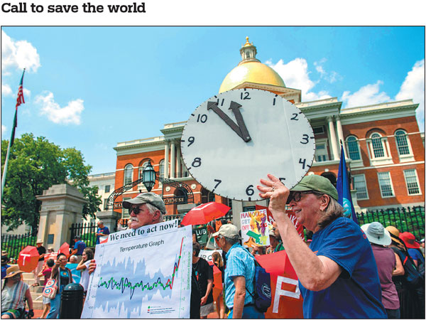 Climate activists march to the State House on Sunday in Boston, Massachusetts, the United States. The activists called upon the state legislature to pass climate related laws to help protect people and the environment.Joseph Prezioso/Afp