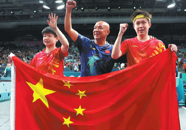 Table tennis players Wang Chuqin (right) and Sun Yingsha (left) celebrate with coach Xiao Zhan on Tuesday after beating Ri Jong Sik and Kim Kum Yong of the Democratic People's Republic of Korea 4-2 to win the mixed doubles final at the Paris Olympics.Liu Xu/Xinhua