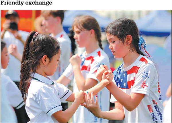 Chinese and US youths exchange Wing Chun skills on Monday in Fuqing, Fujian province. More than 100 young people and guests from China and the United States gathered in Fuqing for an event to explore the charm of Chinese intangible cultural heritage such as the martial art of Wing Chun, Chinese string puppetry and lacquer fans.Xie Guiming/For China Daily