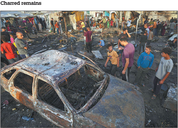 Palestinian residents survey the damage on Monday after an Israeli strike hit temporary accommodations in the courtyard of Al Aqsa Martyrs Hospital in Deir al Balah, Gaza Strip. At least four people were killed in the attack that left dozens of people with severe burns.Abdel Kareem Hana/Ap