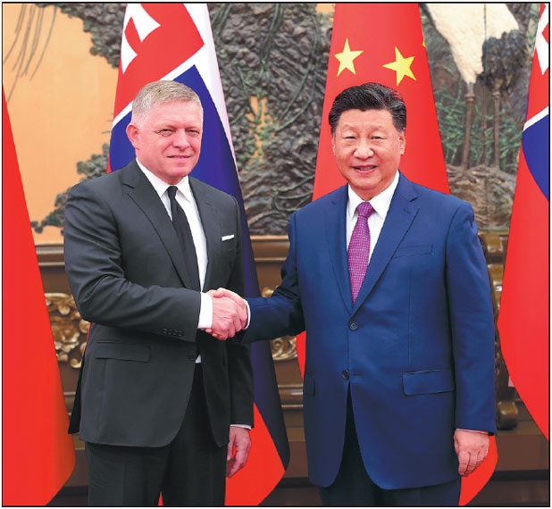 President Xi Jinping shakes hands with Slovak Prime Minister Robert Fico at the Great Hall of the People in Beijing on Friday.  Feng Yongbin / China Daily