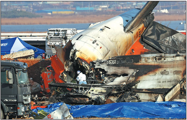 Rescue operations are conducted at Muan International Airport in southwestern South Korea on Sunday after a passenger plane carrying 181 people crashed. The plane, which belly-landed and skidded off the runway, went through a wall and burst into flames.      Yonhap News Agency