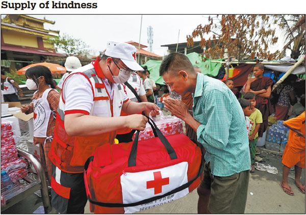 A member of the Red Cross Society of China's international rescue team hands emergency relief supplies on Monday to a local resident in quake-hit Mandalay, the second-largest city in Myanmar. In the aftermath of the magnitude 7.9 quake that struck Myanmar on March 28, Chinese teams were involved in conducting rescue operations, distributing emergency supplies and providing medical services. TAO RAN/FOR CHINA DAILY See more, page 12