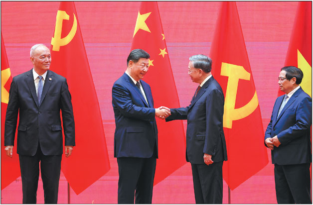 Xi Jinping, general secretary of the Communist Party of China Central Committee and Chinese president, shakes hands with To Lam, general secretary of the Communist Party of Vietnam Central Committee, on Tuesday at the launching ceremony of the China-Vietnam railway cooperation mechanism in Hanoi. Vietnamese Prime Minister Pham Minh Chinh (first from right) and other Chinese and Vietnamese officials also attended the ceremony.       Feng Yongbin / China Daily