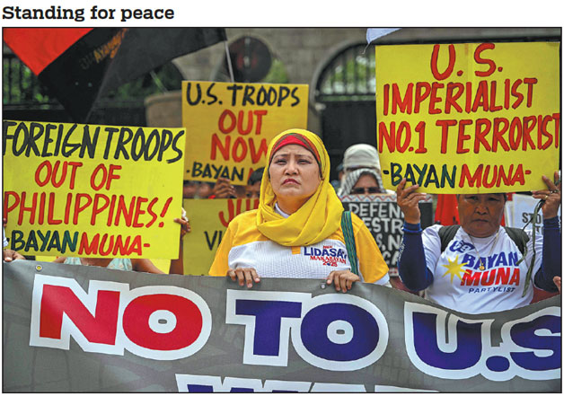 Demonstrators rally outside a military camp in Quezon City, Metro Manila, the Philippines, on Monday, during a protest against the annual Balikatan joint military exercises between the Southeast Asian country and the United States. The three-week drills kicked off the same day amid criticism for posing a threat to regional peace and stability. Jam Sta Rosa / AFP