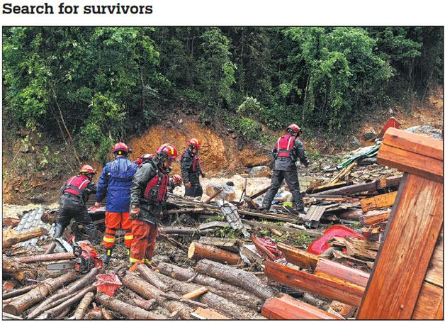 Rescue team members search for survivors on Friday at the site of a mudslide in a village in Longsheng county in Guilin, Guangxi Zhuang autonomous region, after a mountain torrent and mudslide hit early on Friday morning. A preliminary assessment by local authorities showed that eight people were suspected to be missing and 10 houses sustained damage. Rescue efforts are underway in the village.        Wei Jiyang / Xinhua