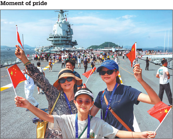 Visitors wave national flags on Saturday during a public tour of the aircraft carrier Shandong in the Hong Kong Special Administrative Region. A fleet of the Chinese People's Liberation Army Navy, led by the Shandong, arrived in Hong Kong on Thursday for a five-day visit. The fleet, which also includes the missile destroyers Yan'an and Zhanjiang and the missile frigate Yuncheng, opened for public tours over the weekend. The event made Hong Kong the first city in China to have hosted two active national aircraft carriers, including the Liaoning in 2017.Edmond Tang/China Daily
