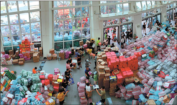 Supplies are stockpiled at a stadium in the flood-hit city of Xinxiang, Henan province, on Sunday. Trucks carrying water and food streamed into the city on Sunday, while soldiers laid sandbags to fill gaps in river dikes that left neighborhoods under water.Dake Kang/ap