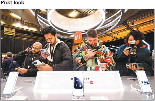 People take pictures of new smartphones of Chinese consumer electronics maker Xiaomi Corp in Barcelona, Spain, on Sunday, ahead of the 2023 Mobile World Congress. The conference began on Monday and will end on Thursday. About 150 Chinese companies are participating in the event, including Huawei, Lenovo and China Mobile.Joan Monfort/AP