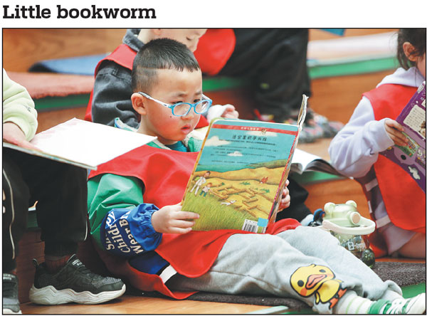 A boy is engrossed in reading a book at Liaoning Provincial Library in Shenyang on Sunday, which marked the World Book and Copyright Day.Xu Huiyang/For China Daily