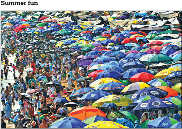 Tourists enjoy their summer time on the beach of Fujiazhuang Park in Dalian, Liaoning province, on Sunday. The coastal city in northeastern China is a magnet for tourists in its peak season every year. Wang Xizeng/For China Daily