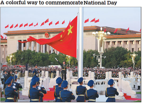 A flag bearer unfurls the national flag in Tian'anmen Square in Beijing on Sunday morning, when a flag-raising ceremony was held to celebrate the 74th anniversary of the founding of the People's Republic of China.   Photos by Zhu Xingxin / China Daily