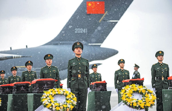 The remains of 25 Chinese soldiers who died during the War to Resist US Aggression and Aid Korea (1950-53) arrive back in their motherland at Shenyang Taoxian International Airport on Thursday. People's Liberation Army soldiers carried caskets, covered by China's national flag, out of the plane for a brief remembrance ritual after the transport aircraft landed.Chen Song/For China Daily