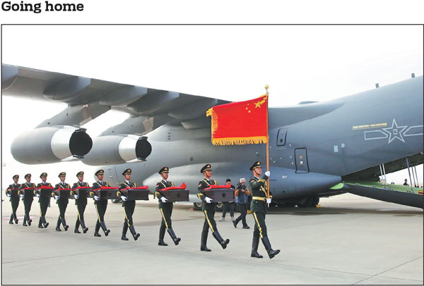 A People's Liberation Army honor guard at Incheon International Airport in Incheon, the Republic of Korea, carries caskets on Thursday containing the remains of Chinese People's Volunteers martyrs in preparation for transportation to China. The remains of 25 Chinese soldiers who died during the War to Resist US Aggression and Aid Korea (1950-53) arrived back in their motherland on Thursday.Yao Qilin/Xinhua