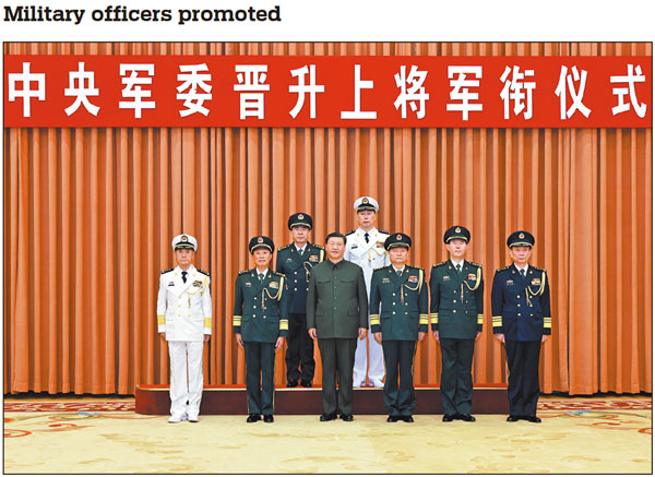 Xi Jinping, chairman of the Central Military Commission, and other leaders have a group photo taken on Monday in Beijing with military officers promoted to the rank of general, the highest rank for officers in active service in China. Xi presented certificates of order to promote Wang Wenquan (back row, left), political commissar of the Southern Theater Command of the People's Liberation Army, and Hu Zhongming (back row, right), commander of the PLA Navy, to the rank of general. LI GANG/XINHUA