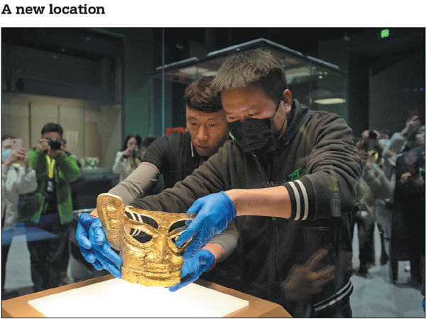 Staff members place a "Golden Mask" of Sanxingdui, an ancient large-scale political entity in Sichuan province, into a display case at the Shanghai Museum East on Monday. The Shanghai Museum East, an extension of the main Shanghai Museum, is located on the east bank of the Huangpu River. The new museum will open to the public on Feb 2.Gao Erqiang/China Daily