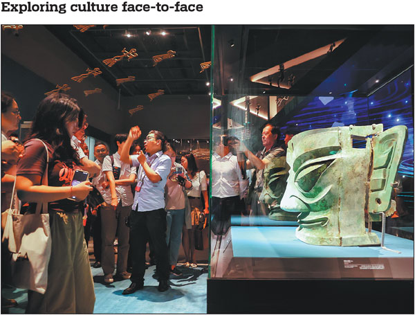Visitors view a giant bronze mask on Thursday at an exhibition showcasing Sanxingdui cultural relics from the ancient Shu civilization. The exhibition, which opened at the Beijing Grand Canal Museum on Thursday and will run through Oct 10, showcases 265 artifacts from 12 museums and cultural institutions.Jiang Dong/China Daily