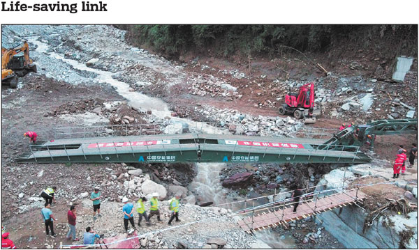 An emergency mechanized bridge is set up across a river after a stone bridge was damaged by floodwaters in Hanyuan county, Sichuan province, on Sunday. A rain-triggered flash flood occurred at around 2:30 am on Saturday, damaging more than 40 houses. As of Monday afternoon, 14 people were confirmed dead and 25 others remained missing. A total of 412 residents have been evacuated due to safety concerns. China Daily