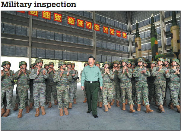 President Xi Jinping, who is also general secretary of the Communist Party of China Central Committee and chairman of the Central Military Commission, talks to officers and soldiers of a brigade of the People's Liberation Army Rocket Force while inspecting its training in operating the arms on Thursday.    Li Gang / Xinhua