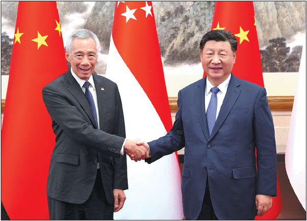 President Xi Jinping shakes hands with Senior Minister of Singapore Lee Hsien Loong during their meeting in Beijing on Tuesday.Feng Yongbin/China Daily