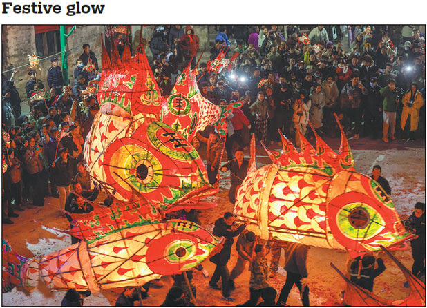 Locals and visitors attend a fish lantern parade in Wangmantian, a village in Shexian county, Anhui province, on Tuesday to mark Lantern Festival, which falls on Wednesday. Fish-shaped lanterns boast a history of over 600 years in the village and are an intangible cultural heritage in Anhui.       Shi Yalei / For China Daily