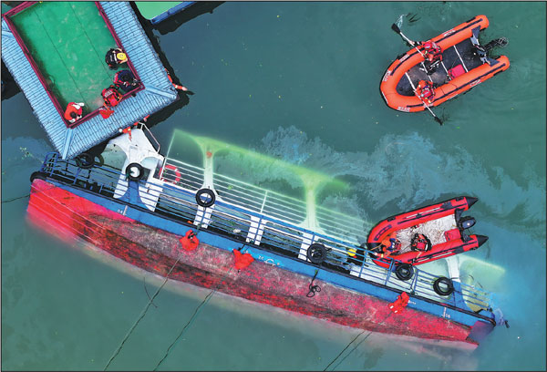 Rescuers search for survivors around a capsized tour boat in Qianxi, Guizhou province, on Monday. Four boats capsized on Sunday afternoon in the Liuguang River due to sudden strong winds, plunging 84 people into the water, 10 of whom died.Liu Xu/Xinhua