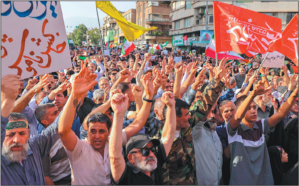 Iranians march with flags and signs in Teheran on Sunday during a rally against the United States' attack on Iran's nuclear sites.Atta Kenare/Afp
