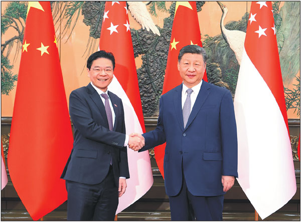 President Xi Jinping shakes hands with Singaporean Prime Minister Lawrence Wong, who is on an official visit to China, at the Great Hall of the People in Beijing on Tuesday.Feng Yongbin/China Daily

